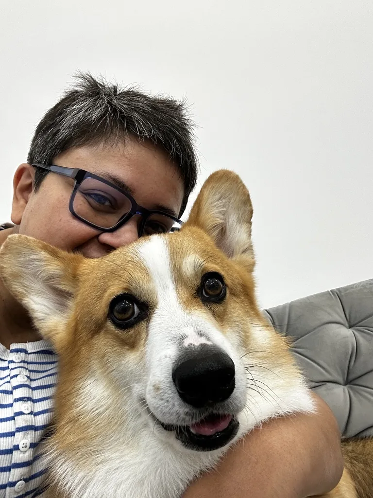 Yajnaseni Mondal, Inhaberin von Greeny's Hundesalon, mit einem Corgi im Arm